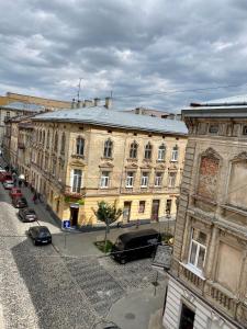 un vecchio edificio con macchine parcheggiate di fronte di Opera Center Hotel & Apartments a Lviv