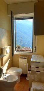bagno con finestra, servizi igienici e lavandino di Casa vista Saint Vincent accanto alle Terme a Saint Vincent