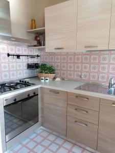 uma cozinha com armários de madeira e um forno com placa de fogão em Casa vista Saint Vincent accanto alle Terme em Saint-Vincent