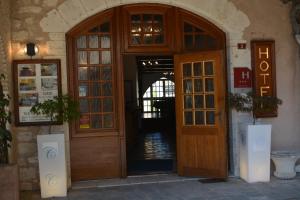 an entrance to a building with a wooden door at Hotel des Consuls in Castelnau-de-Montmiral