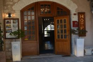 Castelnau-de-Montmiralにあるホテル デ コンスルの木製の扉付きの建物の入口