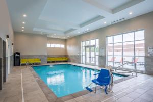 孟菲斯的住宿－Holiday Inn & Suites Memphis Southeast-Germantown, an IHG Hotel，大楼内带蓝色椅子的游泳池