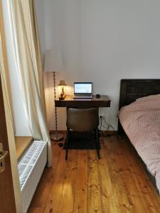 a bedroom with a desk with a laptop computer on it at SOHO Lodge Rasnov in Râşnov