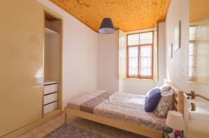 Habitación pequeña con cama y ventana en Casa confortável no centro da cidade en Figueira da Foz