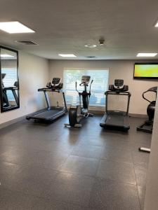 Country Inn & Suites by Radisson, Fort Worth, TX في فورت وورث: صالة ألعاب رياضية مع أجهزةالجري واجهزة الاوبتكال في الغرفة
