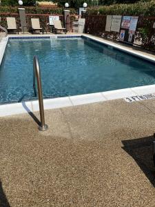 uma piscina com um poste de metal ao lado em Country Inn & Suites by Radisson, Fort Worth, TX em Fort Worth