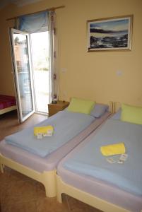 two twin beds in a room with a window at Apartments & Rooms BARBARA in Umag