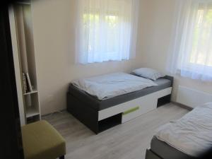 Un dormitorio pequeño con una cama y una ventana. en Aranykagyló 36, en Szigliget