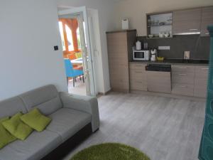 Una sala de estar con un sofá y una cocina. en Aranykagyló 36, en Szigliget