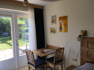 Zimmer mit einem Tisch, 2 Stühlen und einem Fenster in der Unterkunft Carels Kamers Texel in De Koog