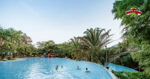 un grupo de personas en una piscina en un complejo en Madagui Forest City en Blao Klong Ner