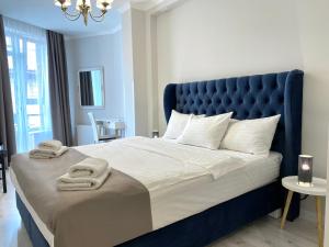a bedroom with a large bed with towels on it at Opera Center Hotel & Apartments in Lviv