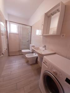 a bathroom with a toilet sink and a washing machine at Apartments Mužić Cres II in Cres