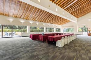 a large banquet hall with red tables and white chairs at Hotel Rancho San Diego Grand Spa Resort in Ixtapan de la Sal