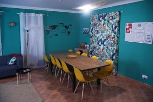 a dining room with a table and yellow chairs at Baleal GuestHouse in Baleal