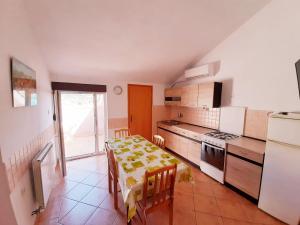 a kitchen with a table with chairs and a kitchen with a tableablish at Apartments Mužić Cres in Cres