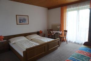 a bedroom with a bed and a table with chairs at Gästehaus Resei in Schiefling am See