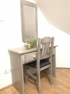 a wooden vanity with a chair and a mirror at Corner Panzió in Szentendre