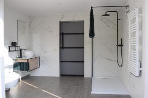 a bathroom with a shower with a glass door at Gastenverblijf ‘t Landsheertje in Veurne