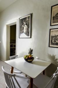 a white dining room table with a bowl of fruit on it at Plakias Riviera in Plakias