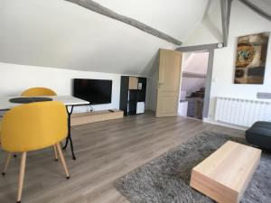 a living room with a table and a yellow chair at Chartres Coeur de Ville, beau 2 pièces chaleureux et lumineux,Parking et Wifi ! in Chartres