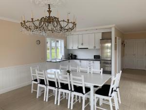 a kitchen with a table and chairs and a chandelier at Vila Bianca in Inturkė +20 photos