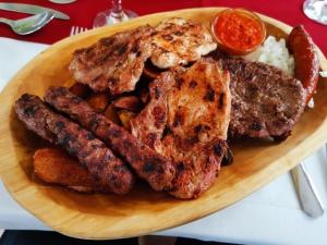 a plate of food with meat and potatoes on a table at Corner Panzió in Szentendre