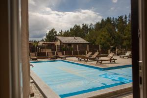 a view of a swimming pool with chairs and a house at Комплекс На Дачі in Vyshpolʼ