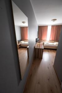 Zimmer mit Blick auf einen Spiegel und ein Schlafzimmer in der Unterkunft Hotel Am Limes in Enns