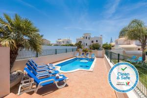 阿尔布费拉Moradia Ricardo - Praia da Gale的游泳池旁的游泳池配有蓝色躺椅