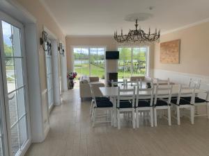 a dining room with a white table and chairs at Vila Bianca in Inturkė