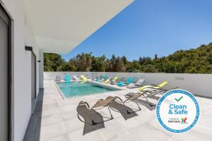 a pool with chairs and a sign that says clean and safe at Luxury 47 in Albufeira