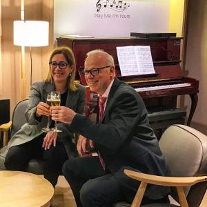 un hombre y una mujer sosteniendo copas de vino con un piano en Aparthotel Silver, en Barcelona