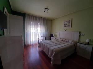 a bedroom with a bed and a table and a window at Favila Oviedo in Oviedo +27 photos