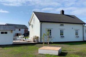 a white house with a tree in a yard at Narnia Lodge Lofoten in Gimsøy