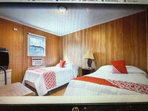 a room with two beds and a television in it at Monmouth OYO in Neptune City