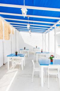 una fila de mesas y sillas con techos azules en Borgo Marino Suite B&B, en Cefalú