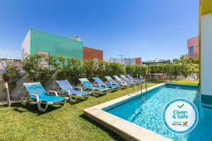 una fila de tumbonas junto a una piscina en Villa 14 Marina de Albufeira, en Albufeira