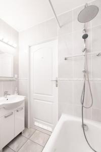 a white bathroom with a shower and a tub and a sink at Willa Przy Plaży in Pogorzelica +15 photos