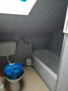 a bathroom with a blue toilet and a bath tub at Richters Deich-Oase in Brokdorf