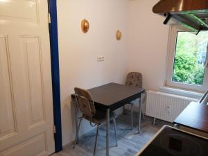 a small kitchen with a table and two chairs at Richters Deich-Oase in Brokdorf