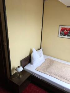um pequeno quarto com uma cama e um espelho em Hotel Zodiak em Radomsko