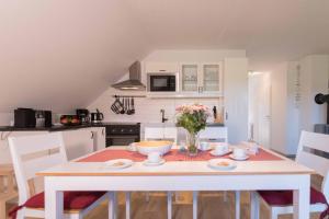 a kitchen with a table with a vase of flowers on it at Born - Wieck DAT SCHWEDENHUS OG-Whg. WI-4.2 in Wieck