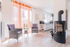 a living room with a fireplace and a table and chairs at Haus DE LOOP in Born