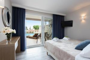 a hotel room with a bed and a sliding glass door at Anita Village in Perama
