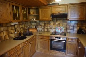 a kitchen with wooden cabinets and a sink and an oven at Gästehaus Resei in Schiefling am See