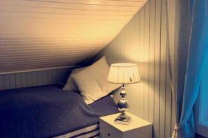 a bedroom with a bed and a lamp on a night stand at Narnia Lodge Lofoten in Gimsøy