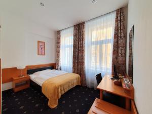 a hotel room with a bed and a desk at Máchova in Prague