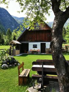 stół piknikowy i ławka przed stodołą w obiekcie Hiska Rutar Valley Voje w mieście Studor v Bohinju