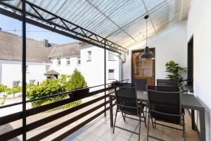 balcón con mesa de comedor y sillas en el patio en Haus Junge Traube, en Bruttig-Fankel